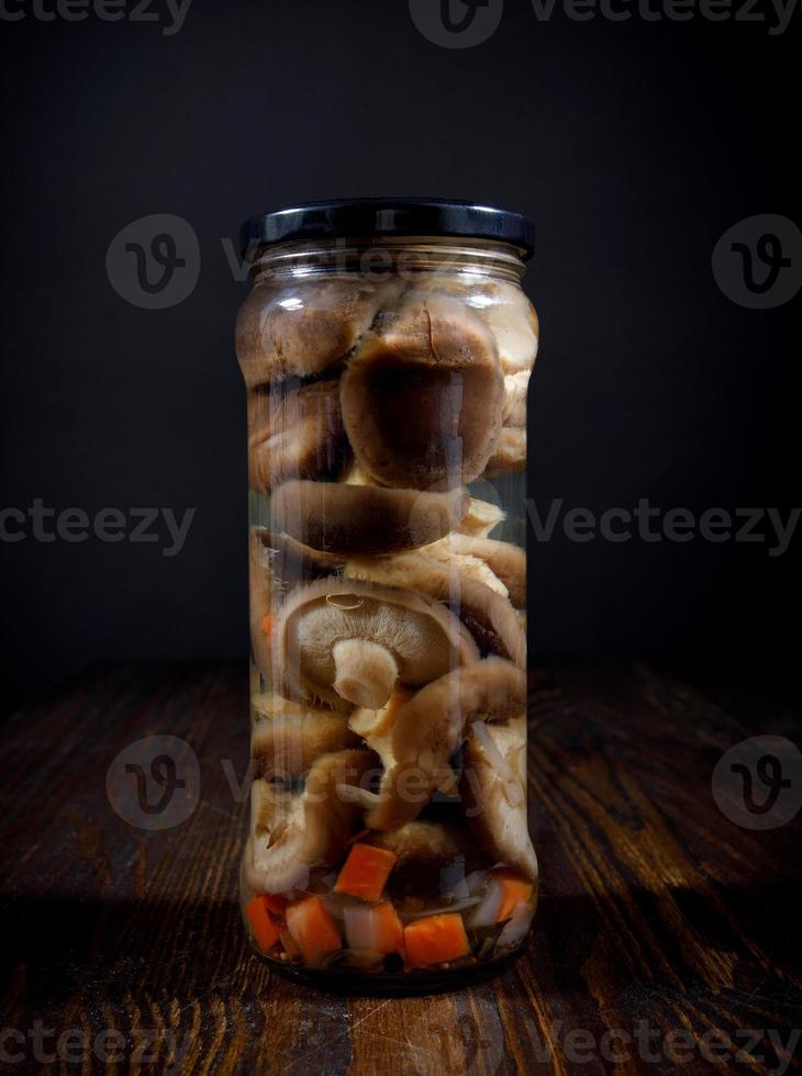 gepekeld champignons met groenten in een glas pot . gezouten eigengemaakt champignons . rustiek voedsel . foto