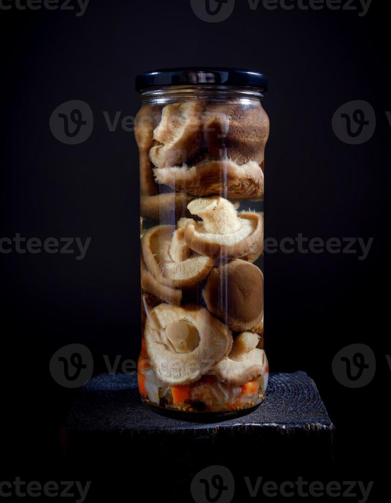 gepekeld champignons in een glas pot . gezouten eigengemaakt champignons . rustiek voedsel . foto