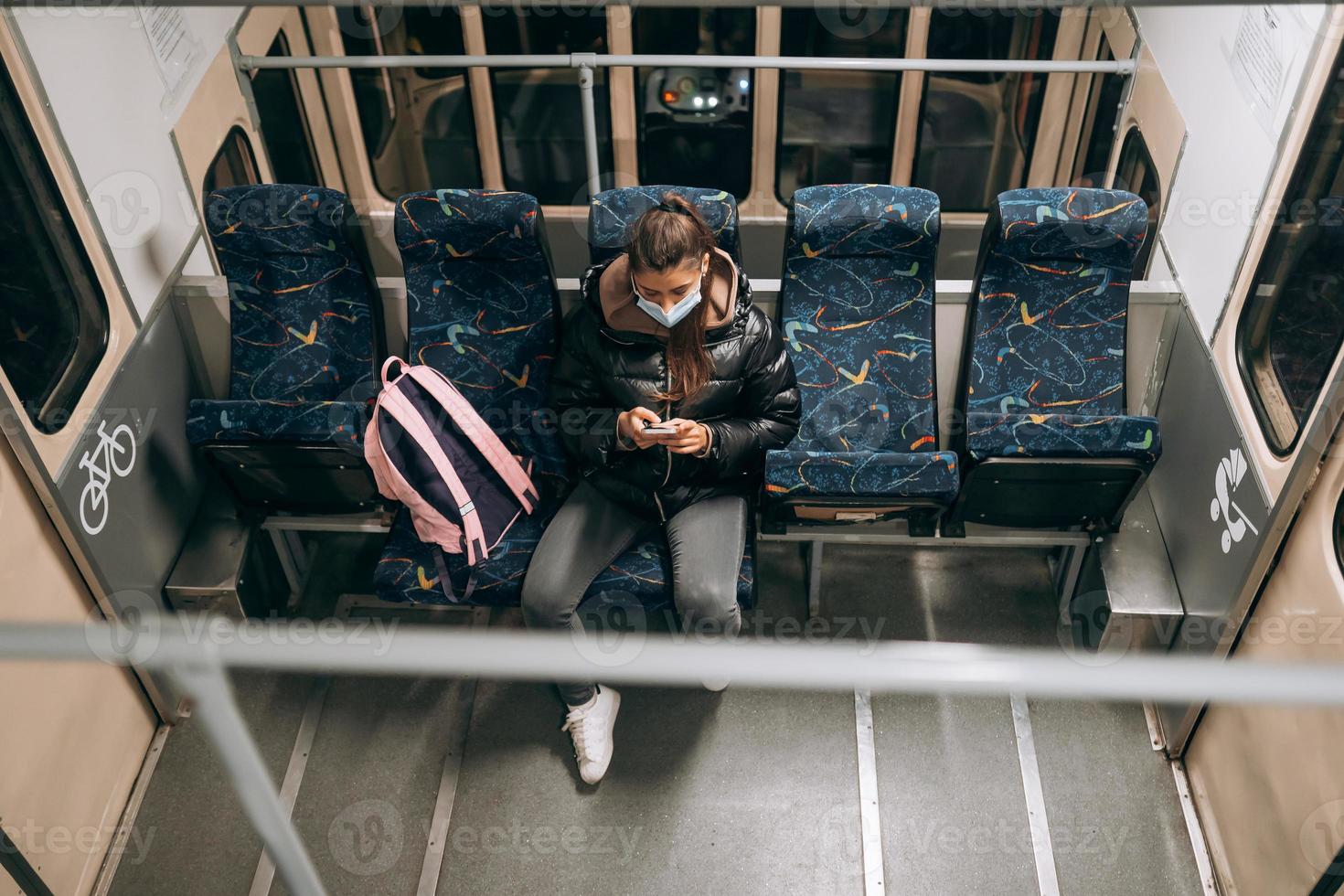 jong vrouw met masker op reis in de openbaar vervoer. foto