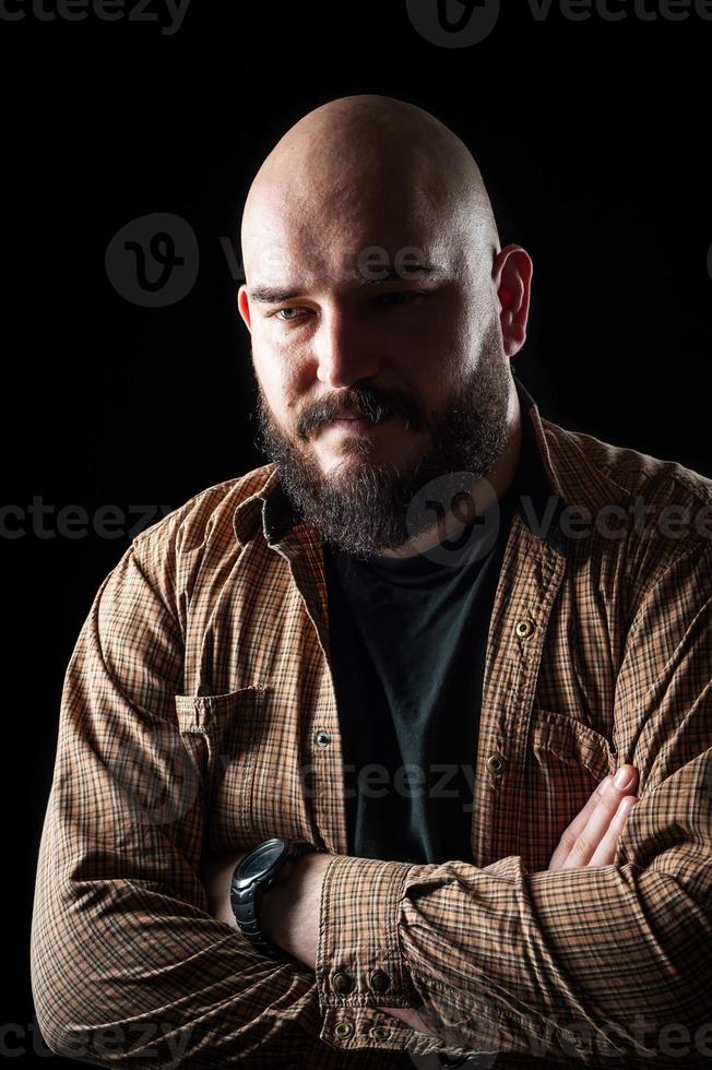 portret van een kale man in een shirt met een baard foto