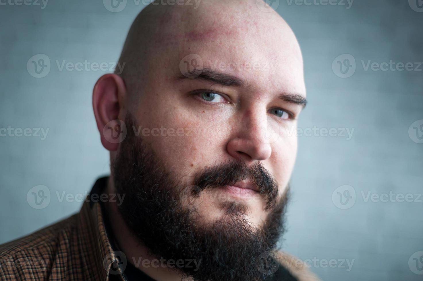 portret van een kale man in een shirt met een baard foto