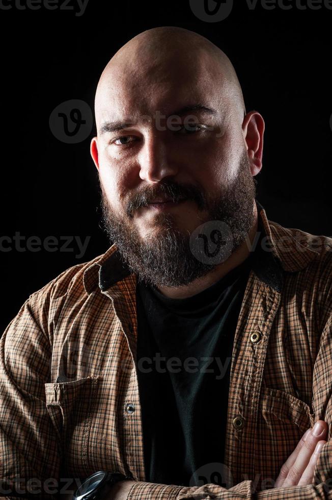 portret van een kale man in een shirt met een baard foto