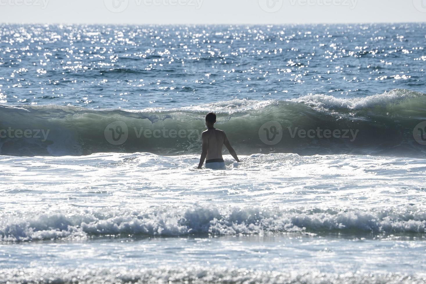 achterzijde visie van zonder shirt Mens wandelen temidden van zee Bij san Diego foto