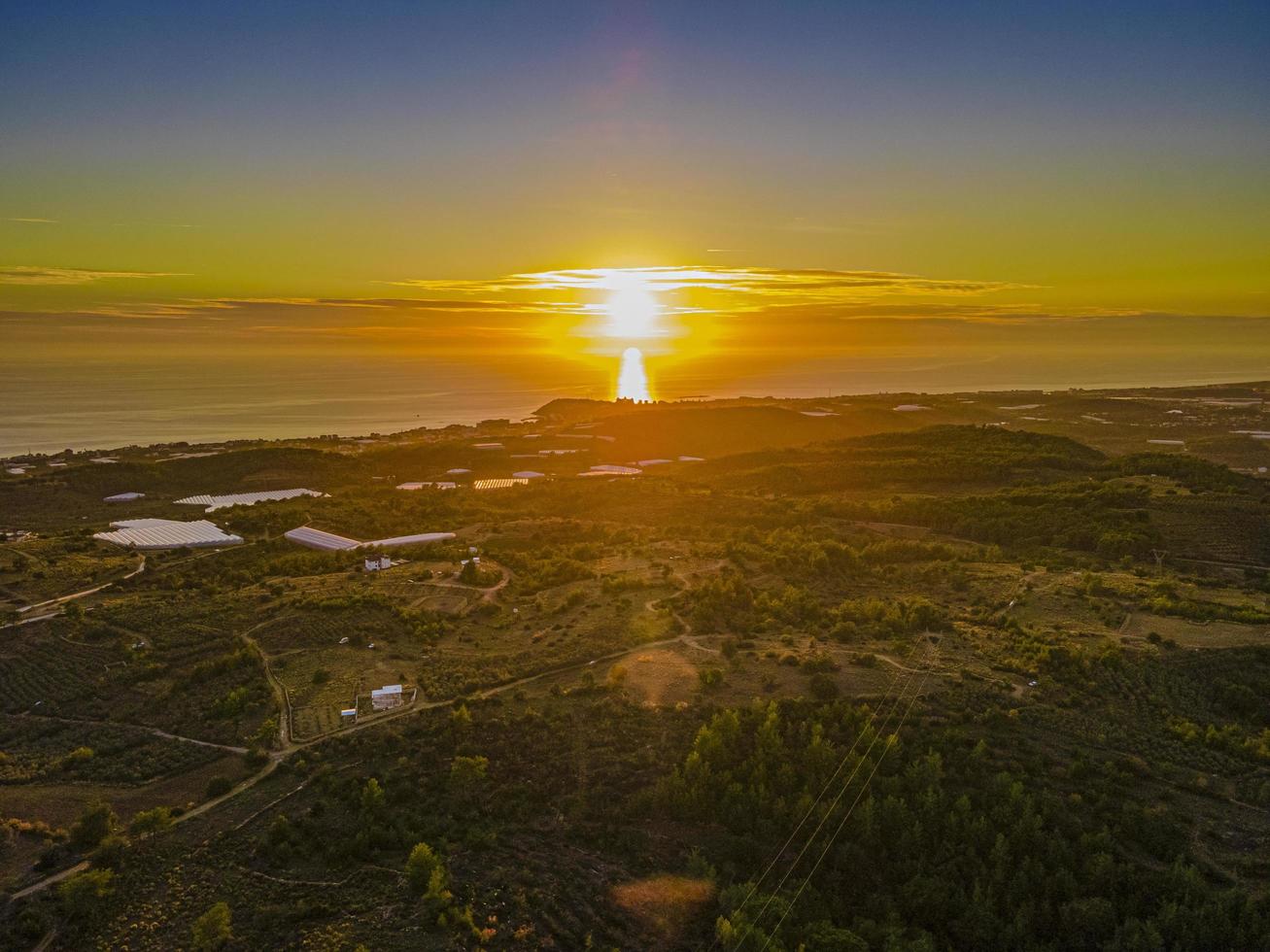 antenne visie van zonsondergang over- bouwland en zee foto