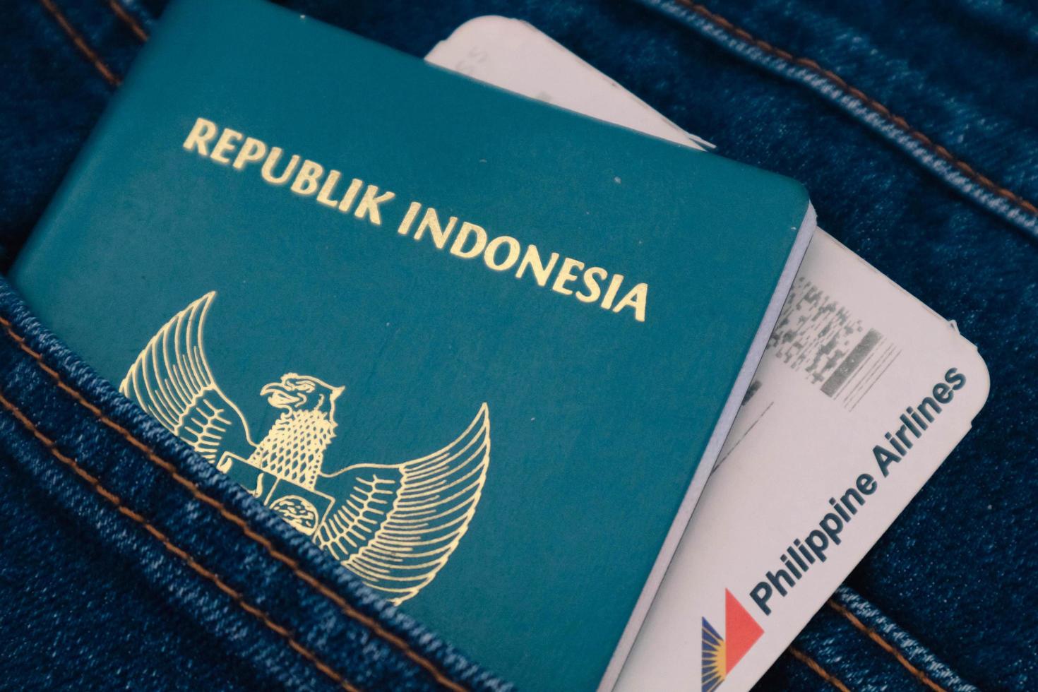 Indonesië in juli 2022. een Indonesisch paspoort en een Filippijnen luchtvaartmaatschappijen instappen voorbij gaan aan in een jeans zak. foto