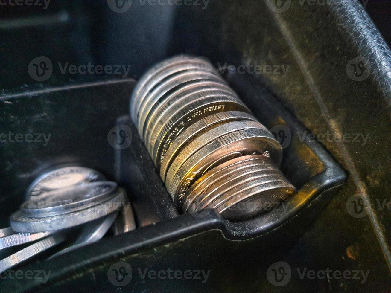 sommige roepia munten en een honderd duizend roepia aantekeningen en sommige andere geld in een doos mits Aan de dashboard van de auto foto