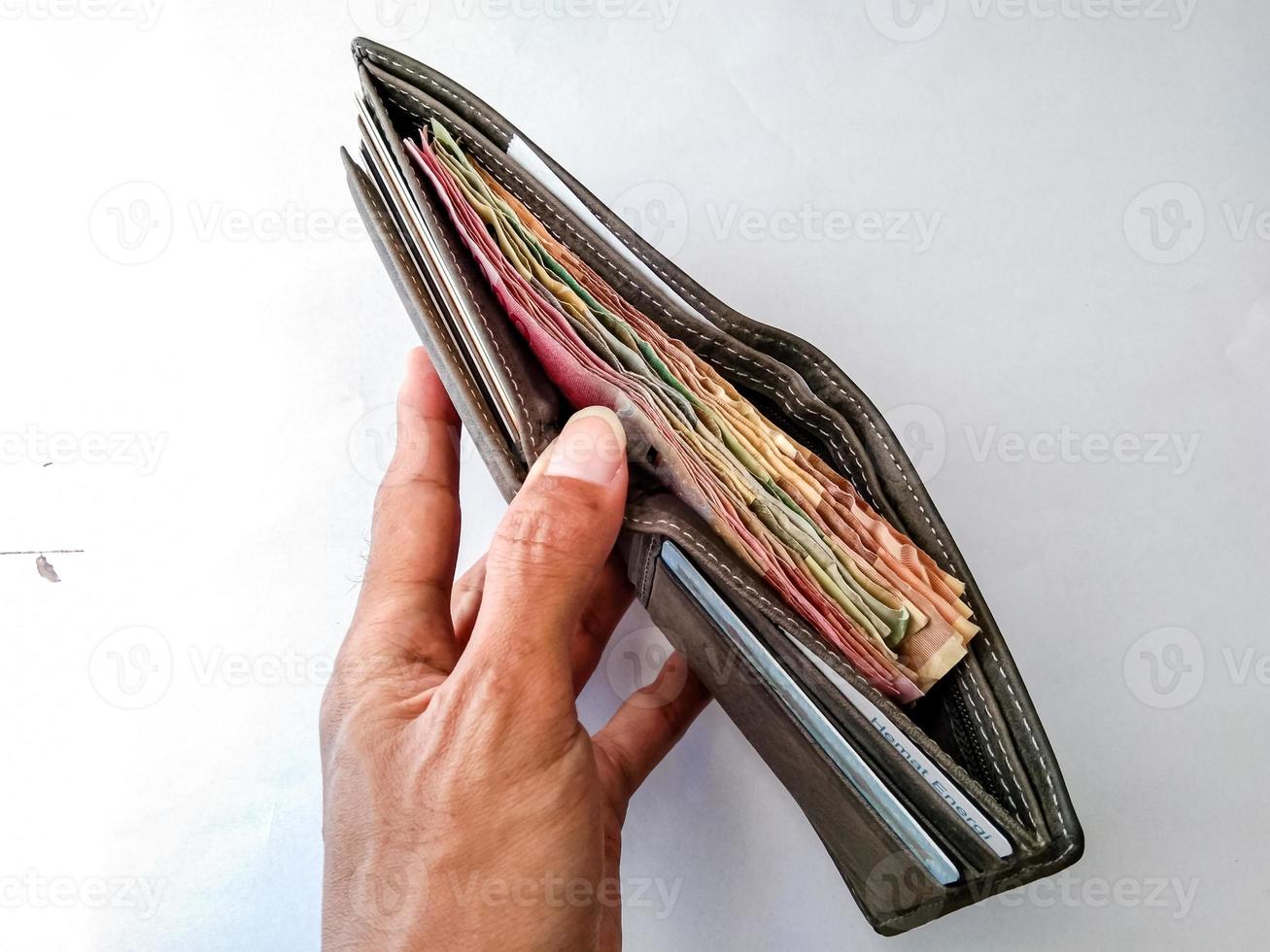 meerdere roepia rekeningen met een bruin portemonnee en een wit achtergrond foto