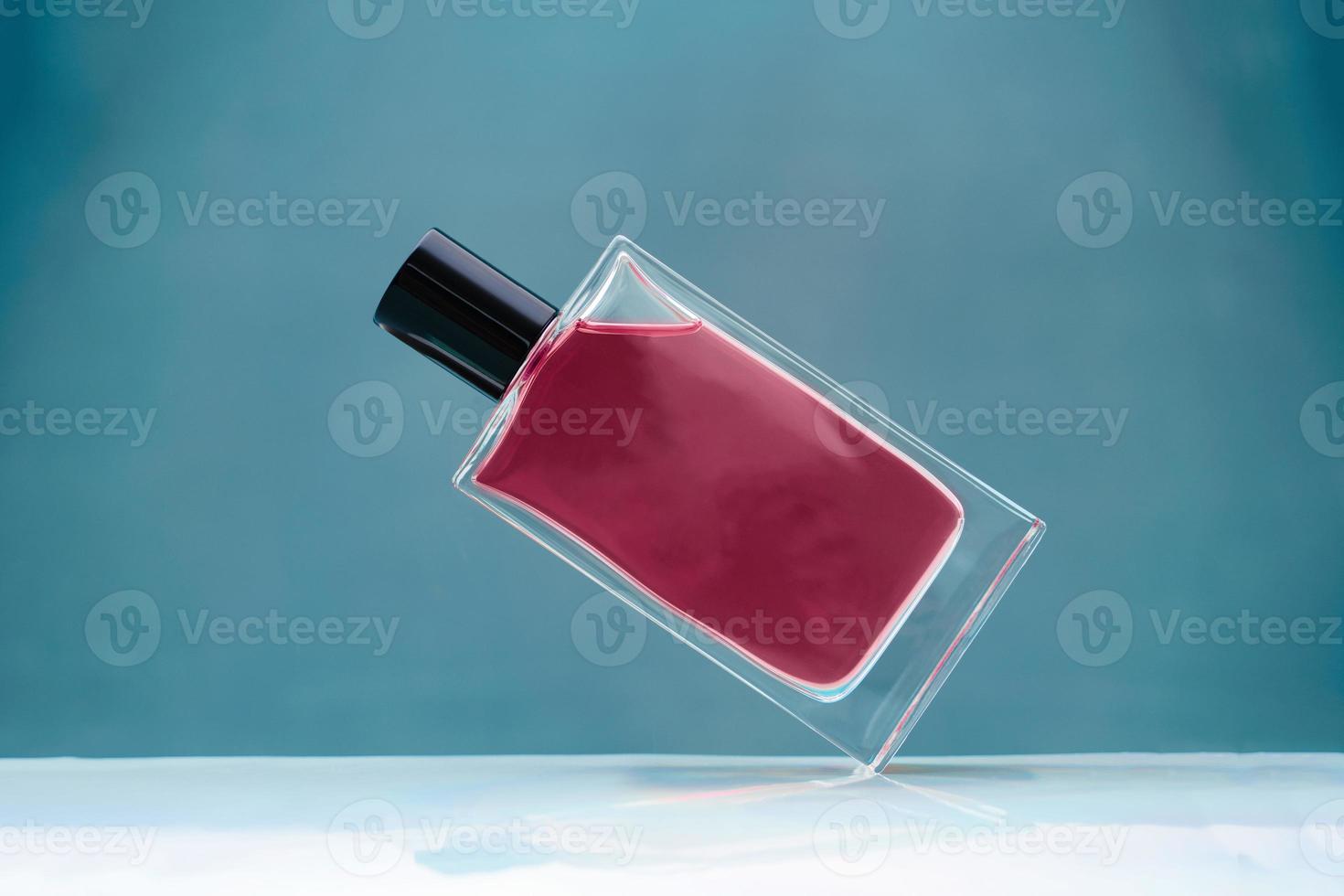 geschorst magenta glas parfum fles Aan blauw achtergrond foto