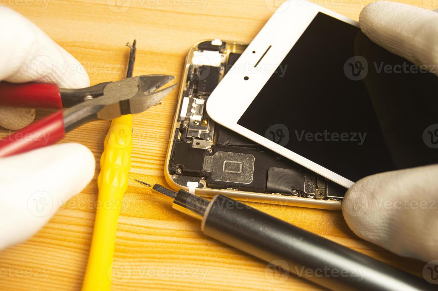 top visie van een technicus repareren een smartphone foto