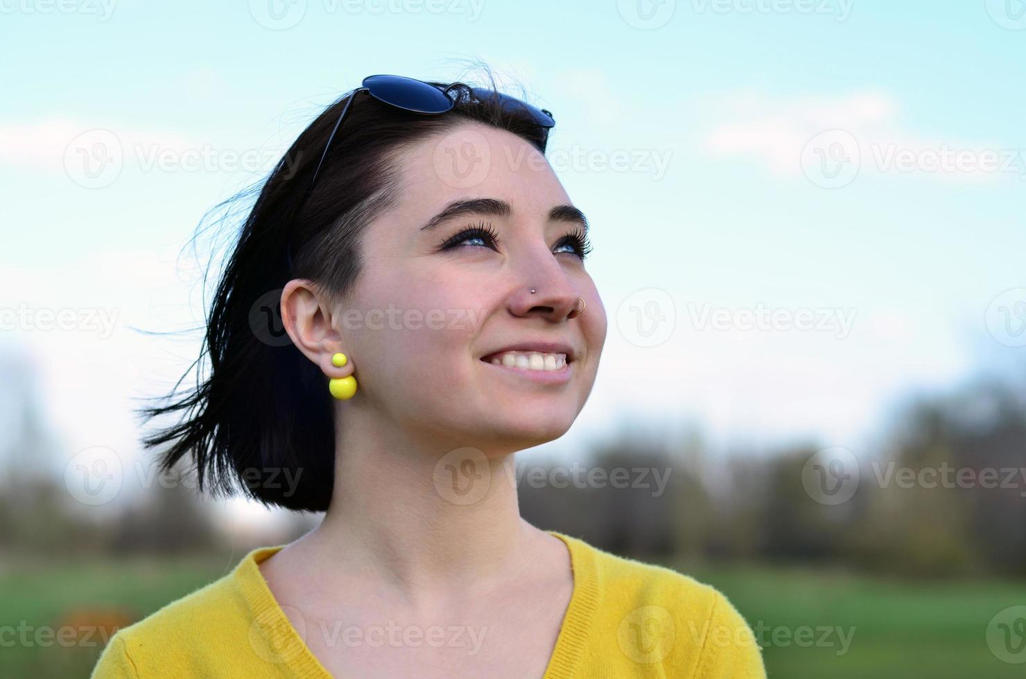 aantrekkelijk en schattig brunette meisje in een geel trui tegen een foto