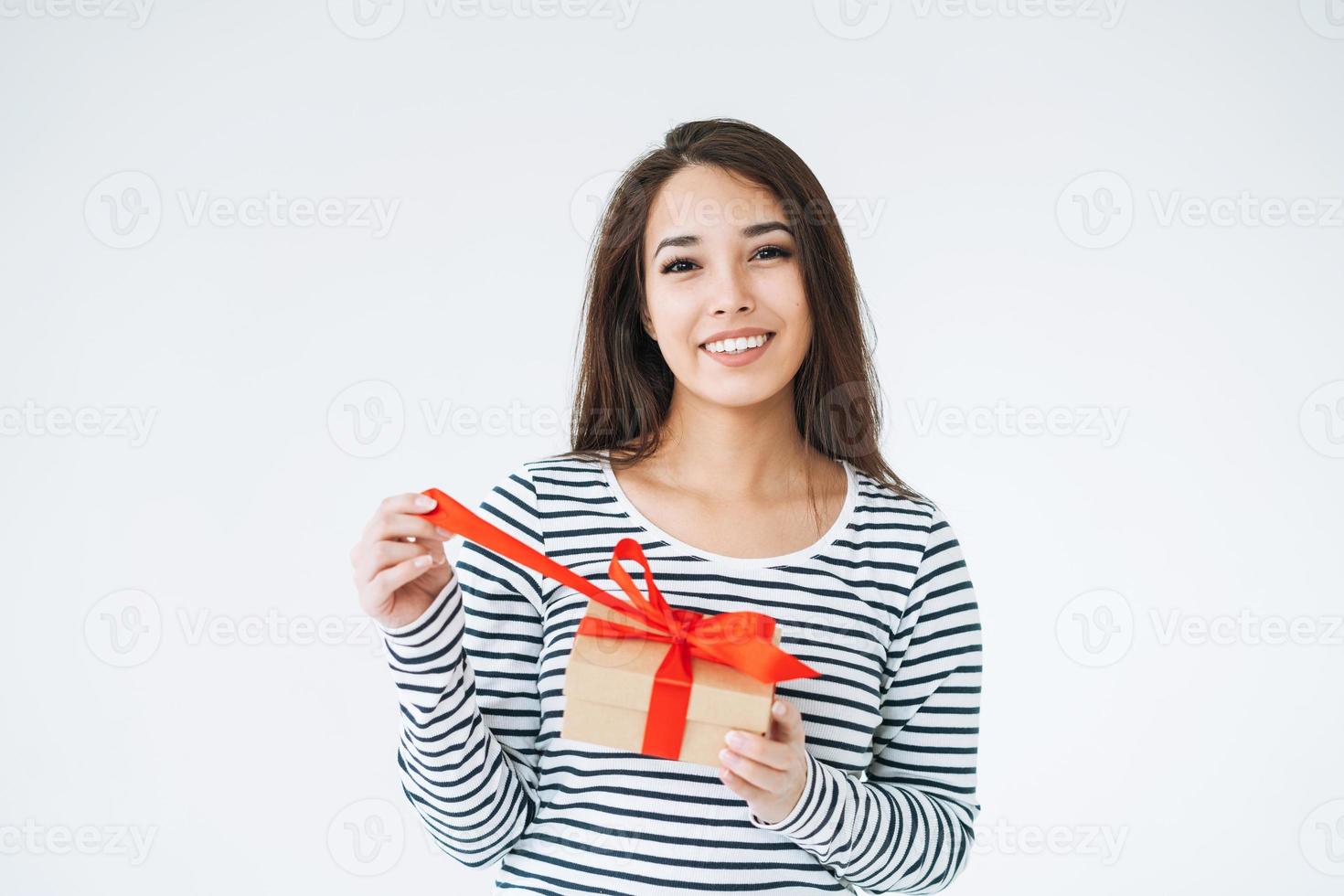 portret van jong glimlachen Aziatisch vrouw met geschenk doos in handen Aan wit achtergrond geïsoleerd foto