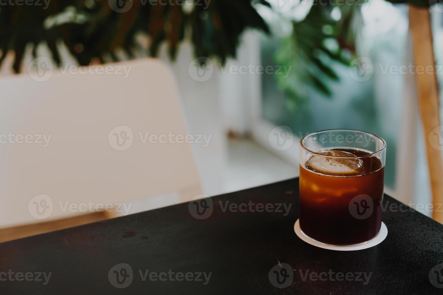 zwart koffie verkoudheid druppelen in glas foto