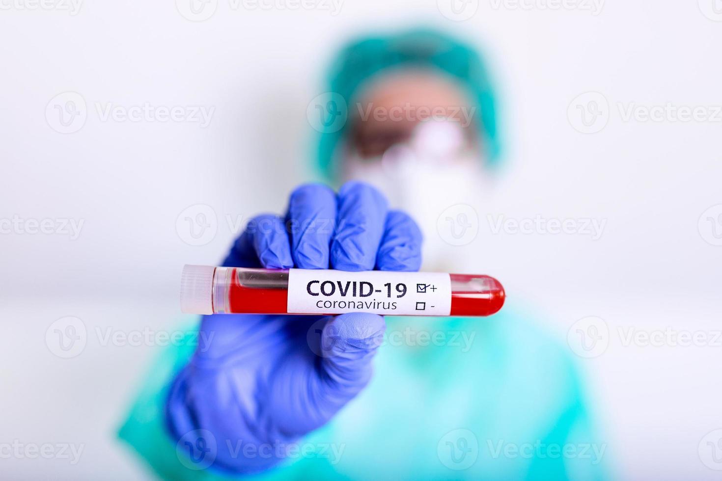 covid19, corona virus of roman coronavirus epidemie ziekte met dokter of laboratorium technicus wetenschapper in ppe persoonlijk beschermend uitrusting Holding bloed buis test in ziekenhuis laboratorium foto