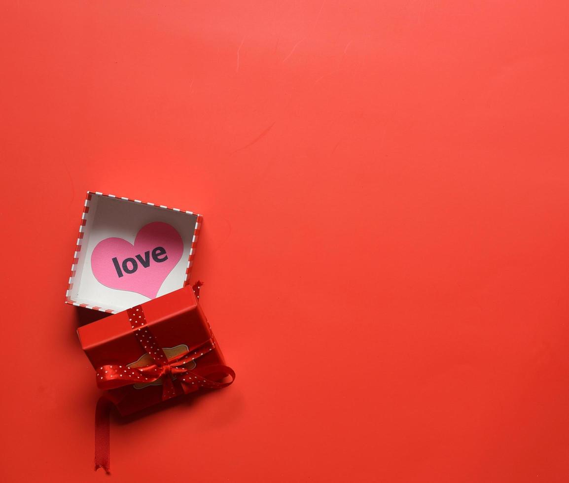 top visie van Open rood giftbox met liefde hart Aan de doos in rood achtergrond - valentijn, verjaardag, verjaardag foto