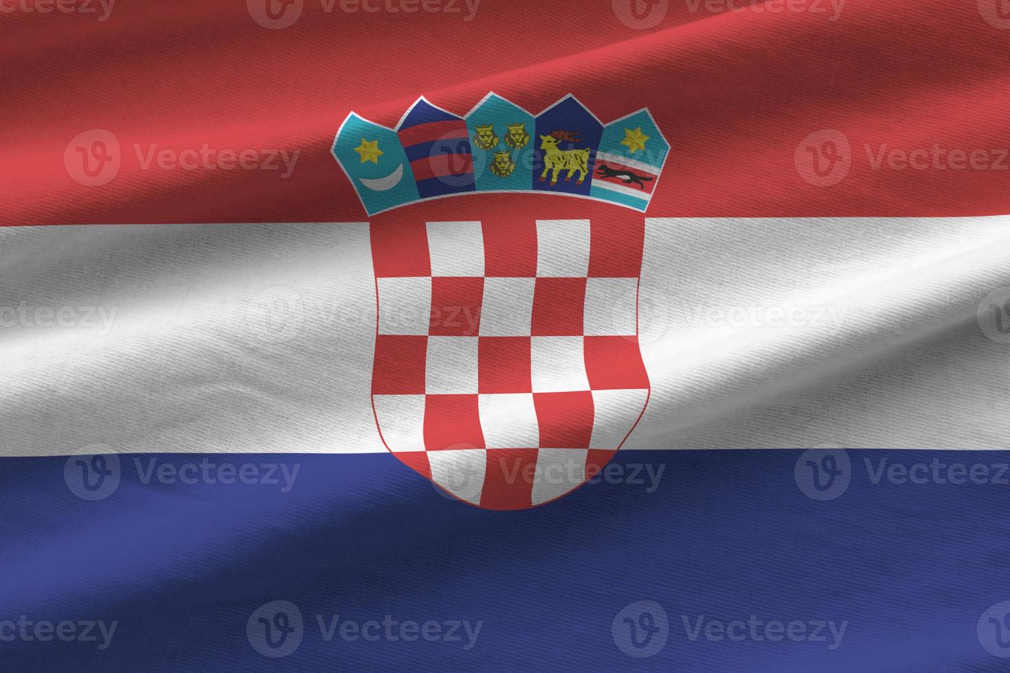 Kroatië vlag met groot vouwen golvend dichtbij omhoog onder de studio licht binnenshuis. de officieel symbolen en kleuren in banier foto