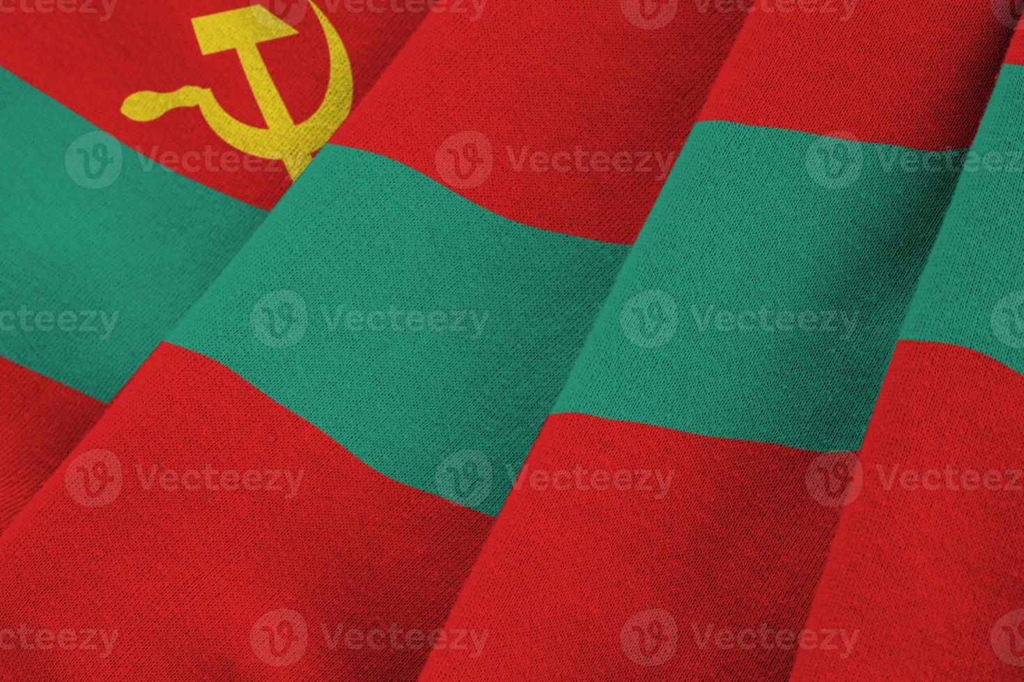 transnistria vlag met groot vouwen golvend dichtbij omhoog onder de studio licht binnenshuis. de officieel symbolen en kleuren in banier foto