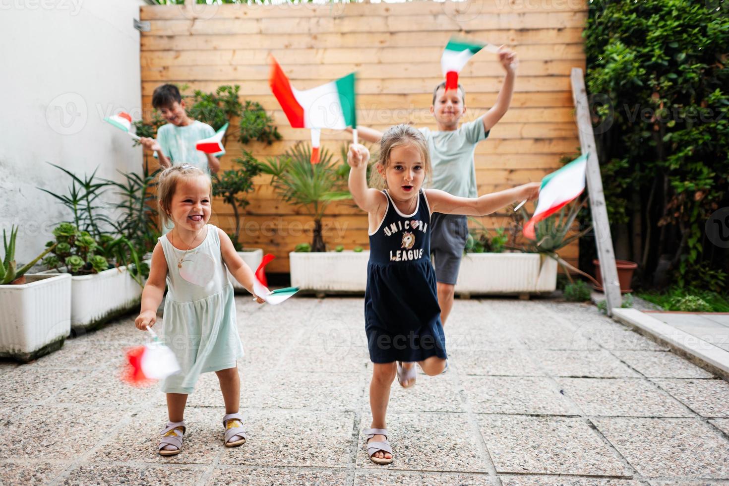 gelukkig vier kinderen met Italiaans vlaggen vieren republiek dag van Italië. foto