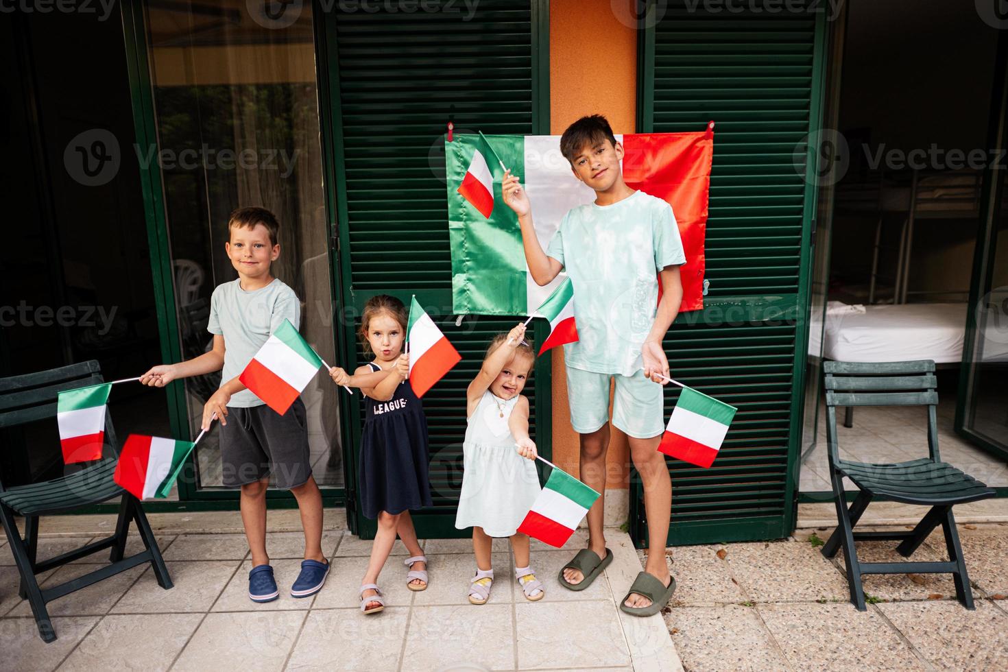 gelukkig vier kinderen met Italiaans vlaggen vieren republiek dag van Italië. foto