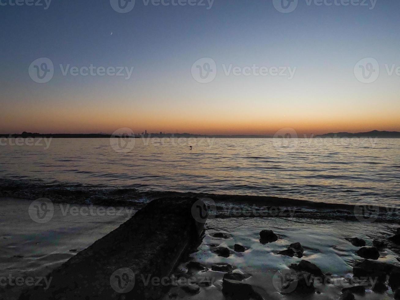 geel, blauw, oranje lucht Bij zonsondergang Aan de baai. foto