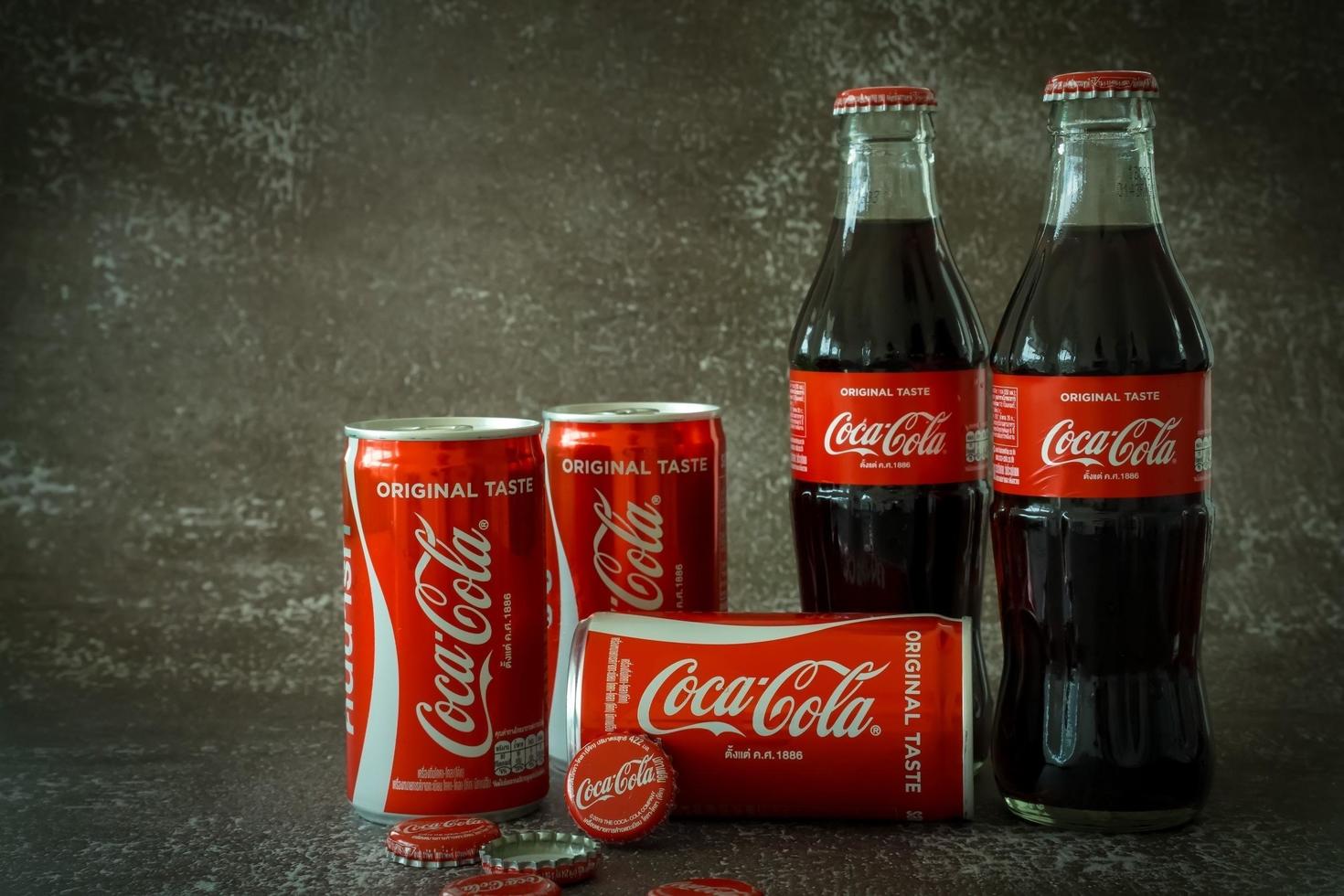 ayutthaya, thailand-25juni2020- Coca Cola klassiek in een glas fles en kan Aan donker afgezwakt cement achtergrond. coca cola, cokes is de meest populair koolzuurhoudend zacht drinken dranken verkocht in de omgeving van de wereld foto