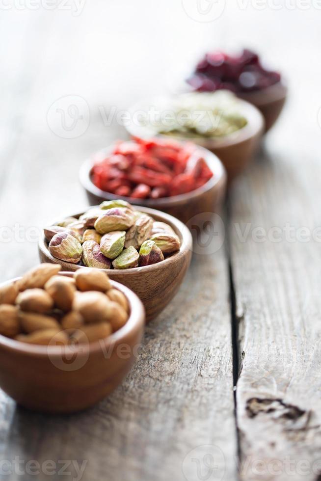 verscheidenheid van noten en droog fruit in klein kommen foto