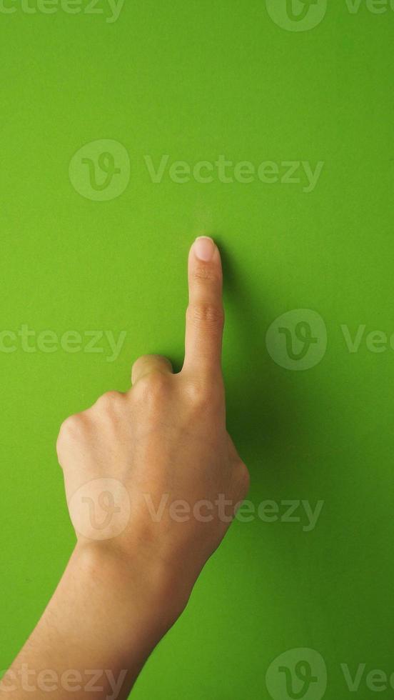 menselijk vinger aanraken of richten Aan groen scherm achtergrond en in studio. foto