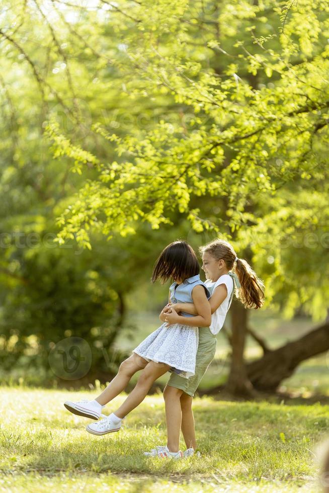 schattig Aziatisch en Kaukasisch meisje hebben pret in de park foto