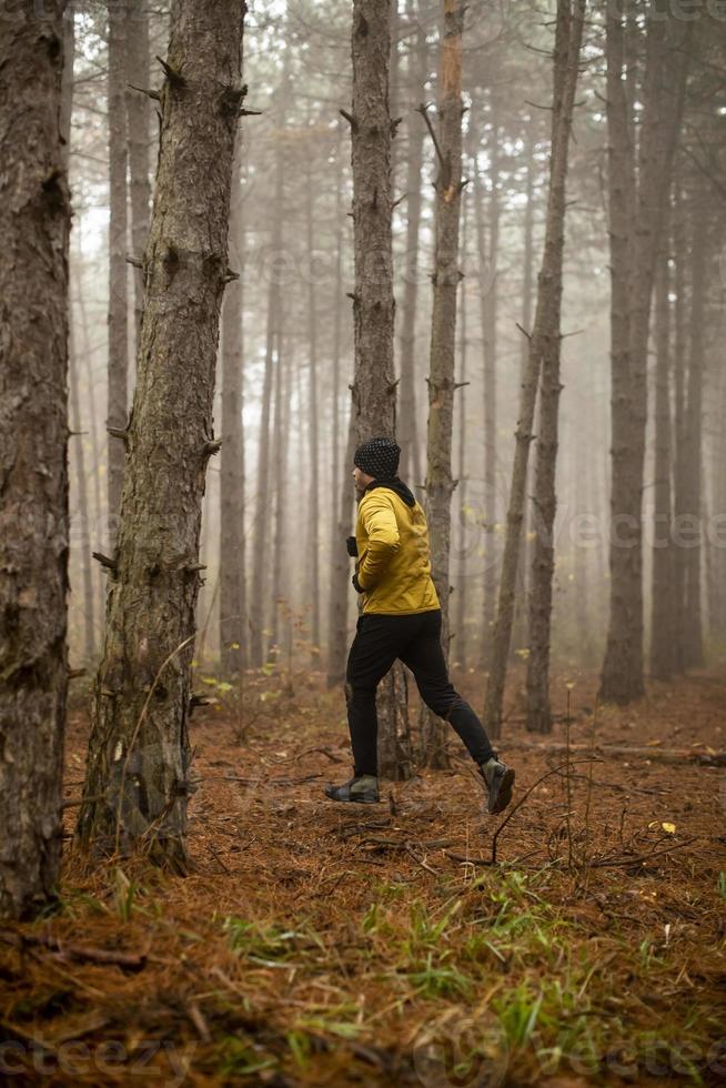 jong Mens rennen in herfst Woud en oefenen voor spoor rennen marathon uithoudingsvermogen ras foto