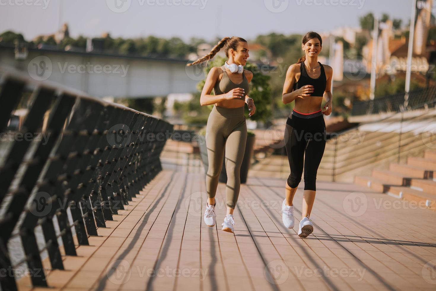 jonge vrouw die hardloopoefeningen doet aan de rivierpromenade foto