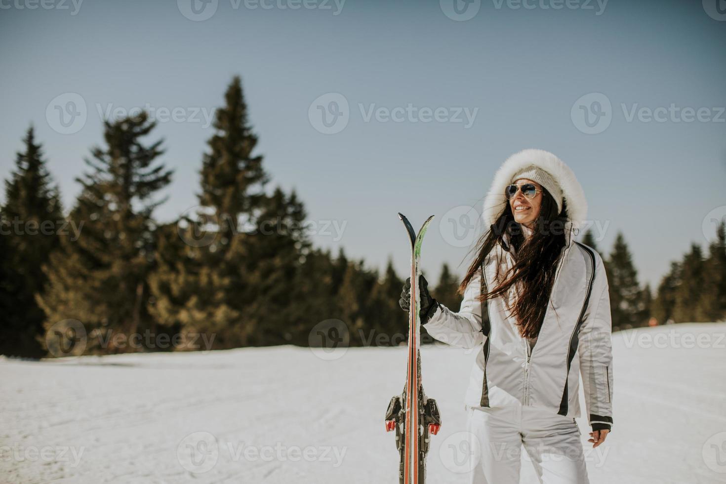 jong vrouw staand met skis Aan de ski bijhouden foto