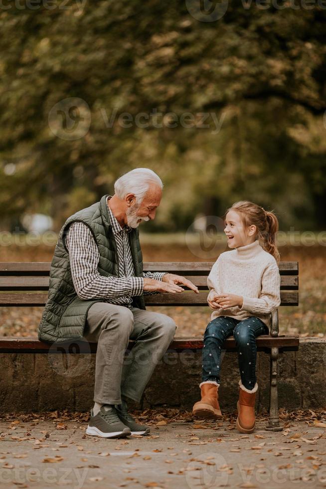 opa spelen rood handen meppen spel met zijn kleindochter in park Aan herfst dag foto