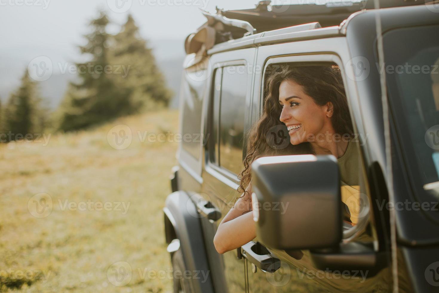 jonge vrouw die op een zonnige dag geniet van vrijheid in een terreinvoertuig foto