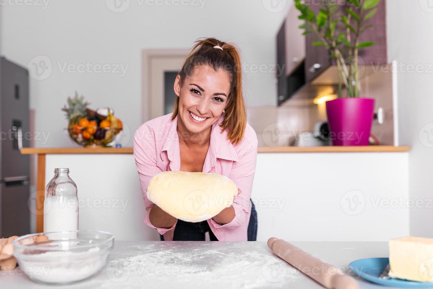 gelukkig aantrekkelijk jong volwassen vrouw dame huisvrouw bakker Holding pin rollend deeg Aan keuken tafel bakken gebakje concept Koken taart biscuit aan het doen bakkerij Bij huis foto