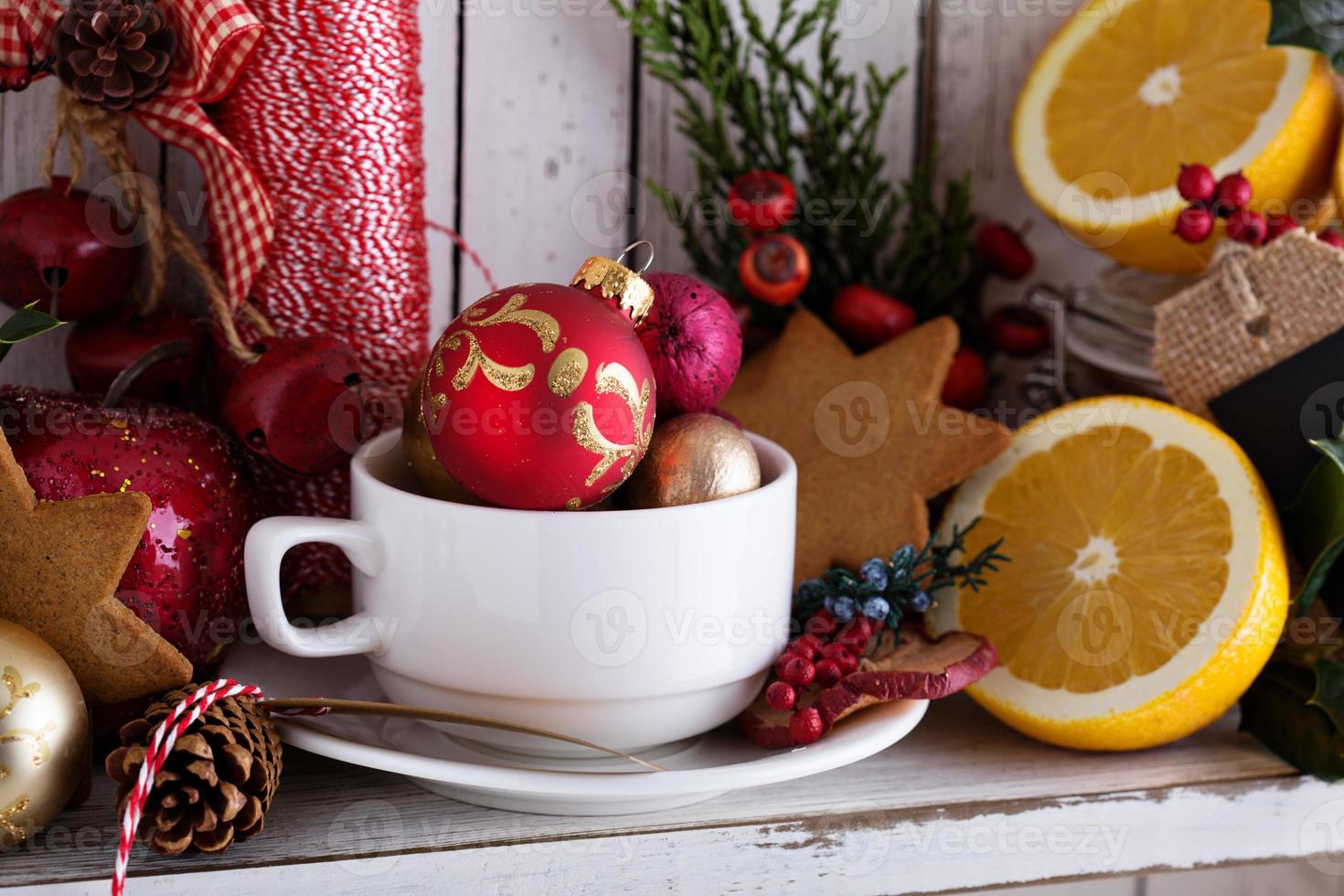 thee kop met decoraties, koekjes en sinaasappels voor Kerstmis foto