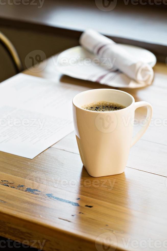 kop van vers gebrouwen koffie Aan een restaurant tafel foto