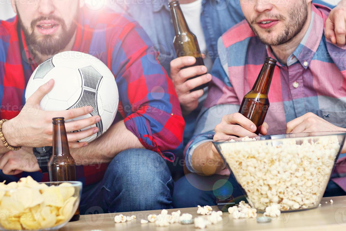 gelukkig mannetje vrienden juichen en aan het kijken sport- Aan TV foto