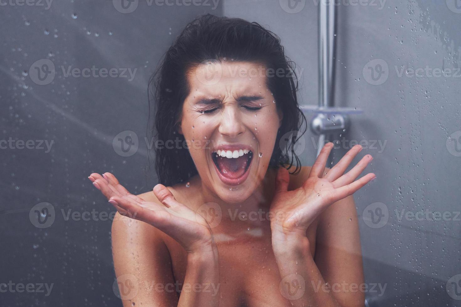volwassen vrouw onder de douche in badkamer foto