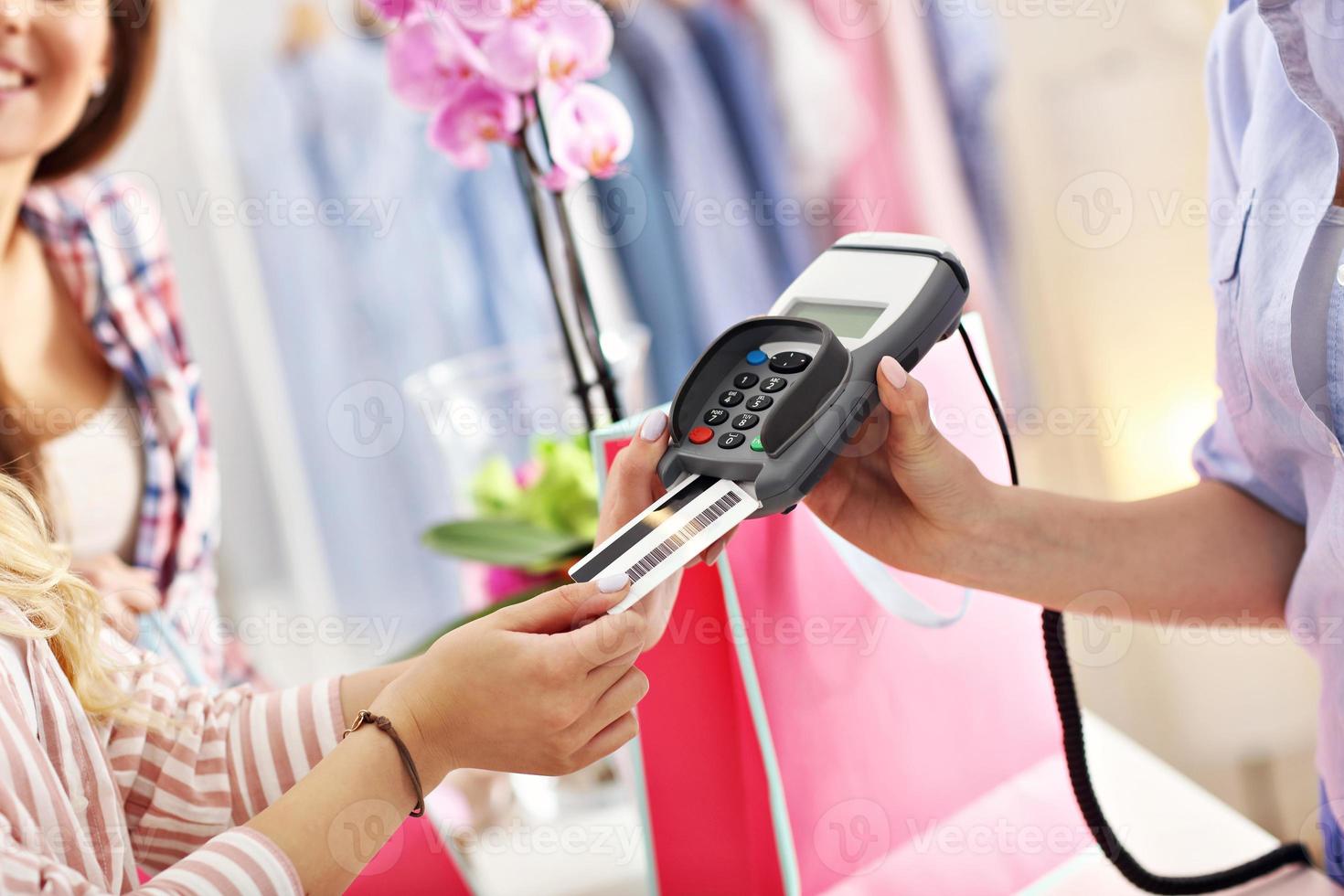 detailopname midden sectie van vrouw klant betalen in winkel met credit kaart foto