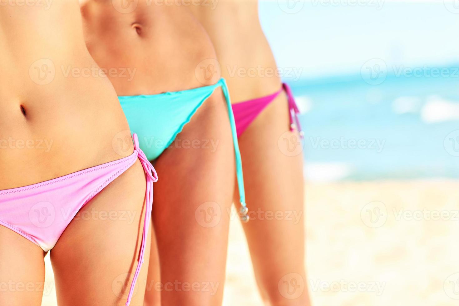 vrouw poten en buiken in bikini Aan de strand foto