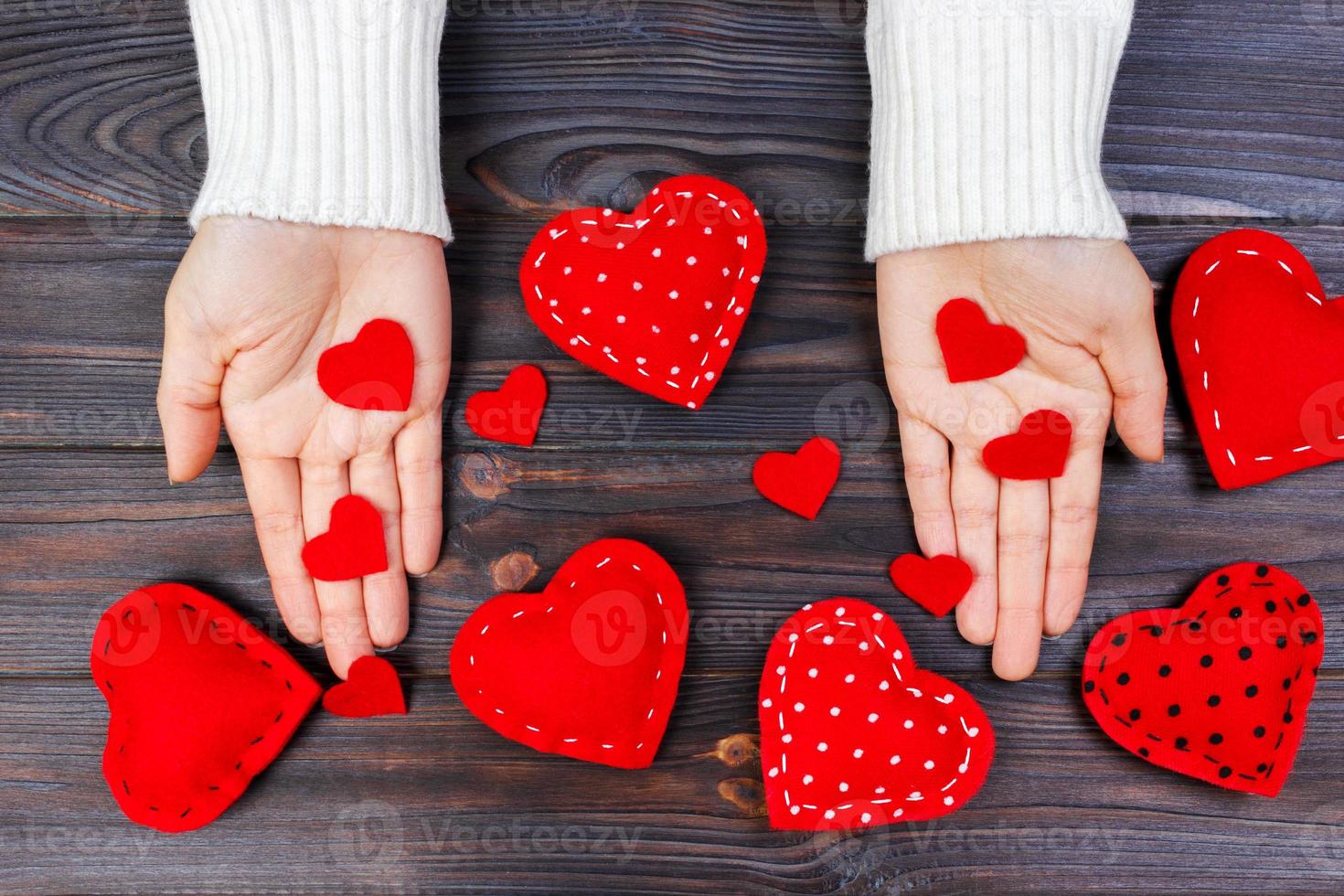 rood hart Aan vrouw hand- Aan houten achtergrond met kopiëren ruimte. concept voor valentijnsdag dag viering of paar van liefde. liefde concept foto