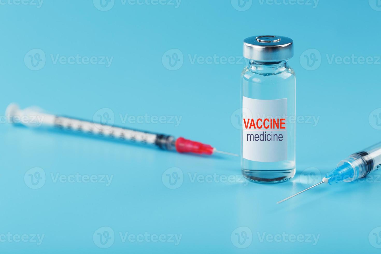 ampul van vaccin geneeskunde met een injectiespuit Aan een blauw achtergrond. foto