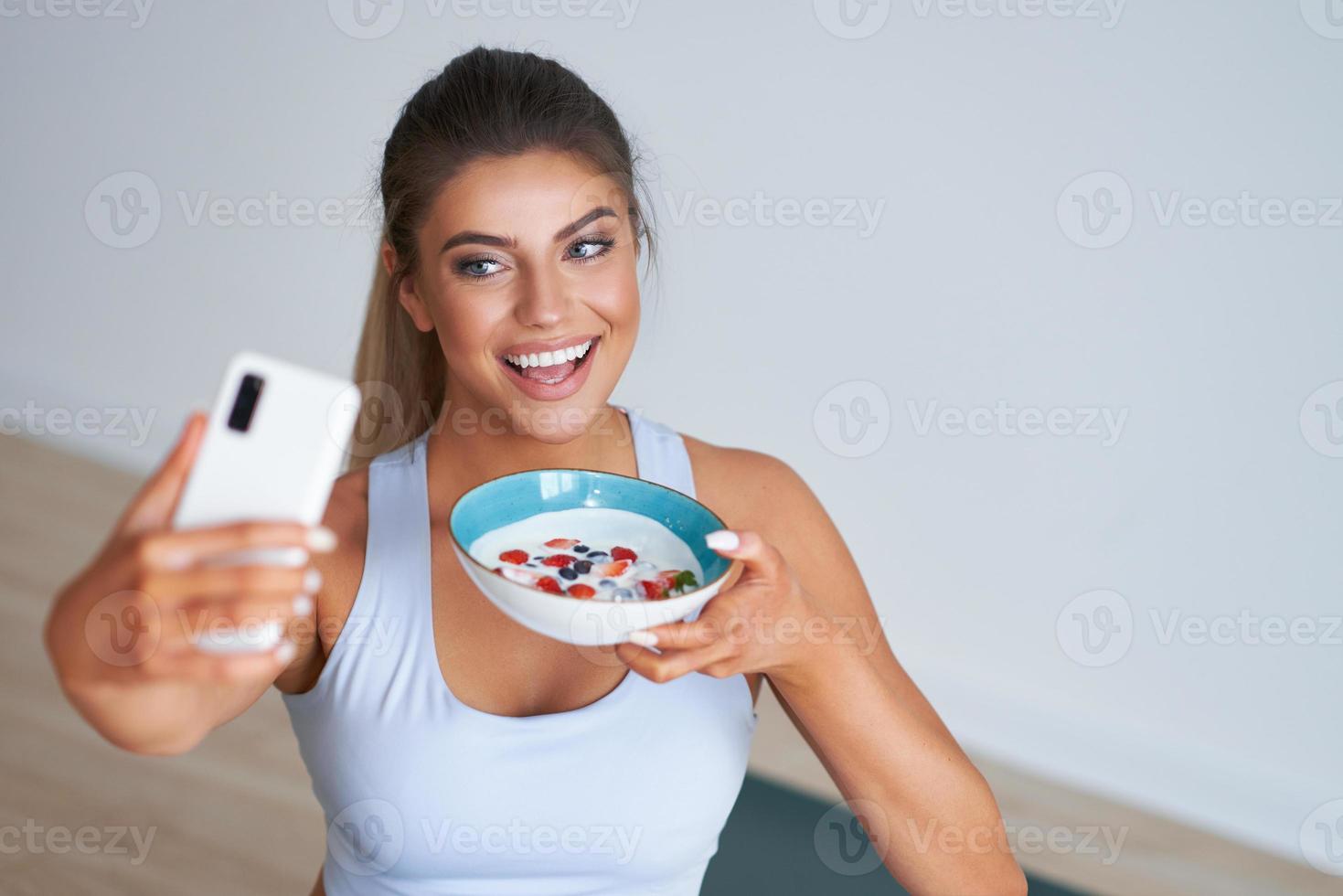 portret van mooi spaans vrouw aan het eten yoghurt bevorderen gezond levensstijl foto