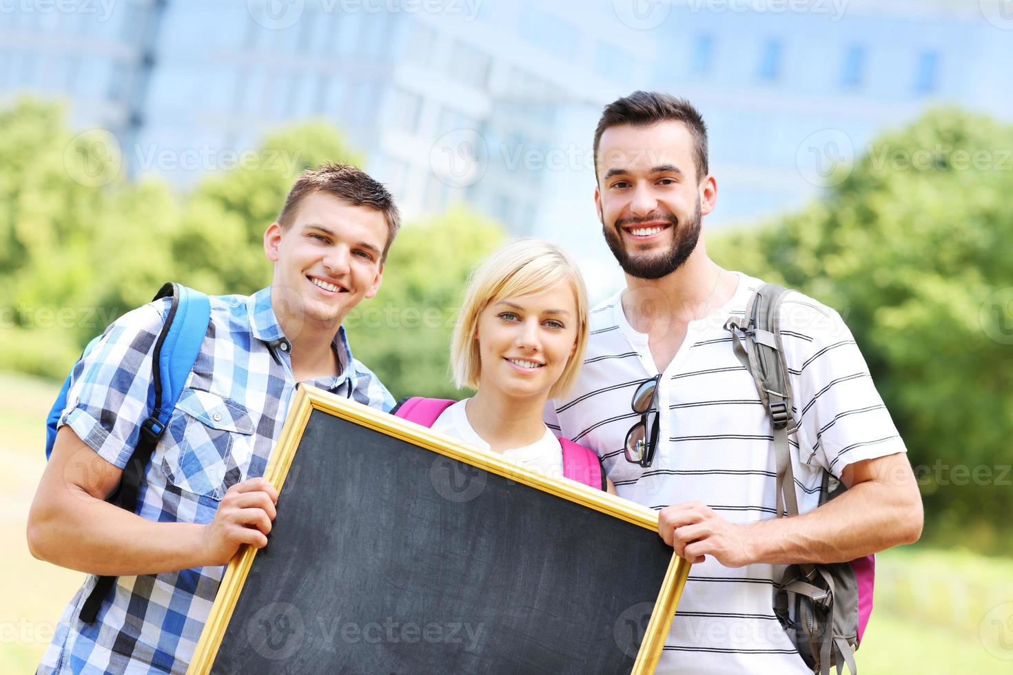 groep van studenten Holding een schoolbord in de park foto