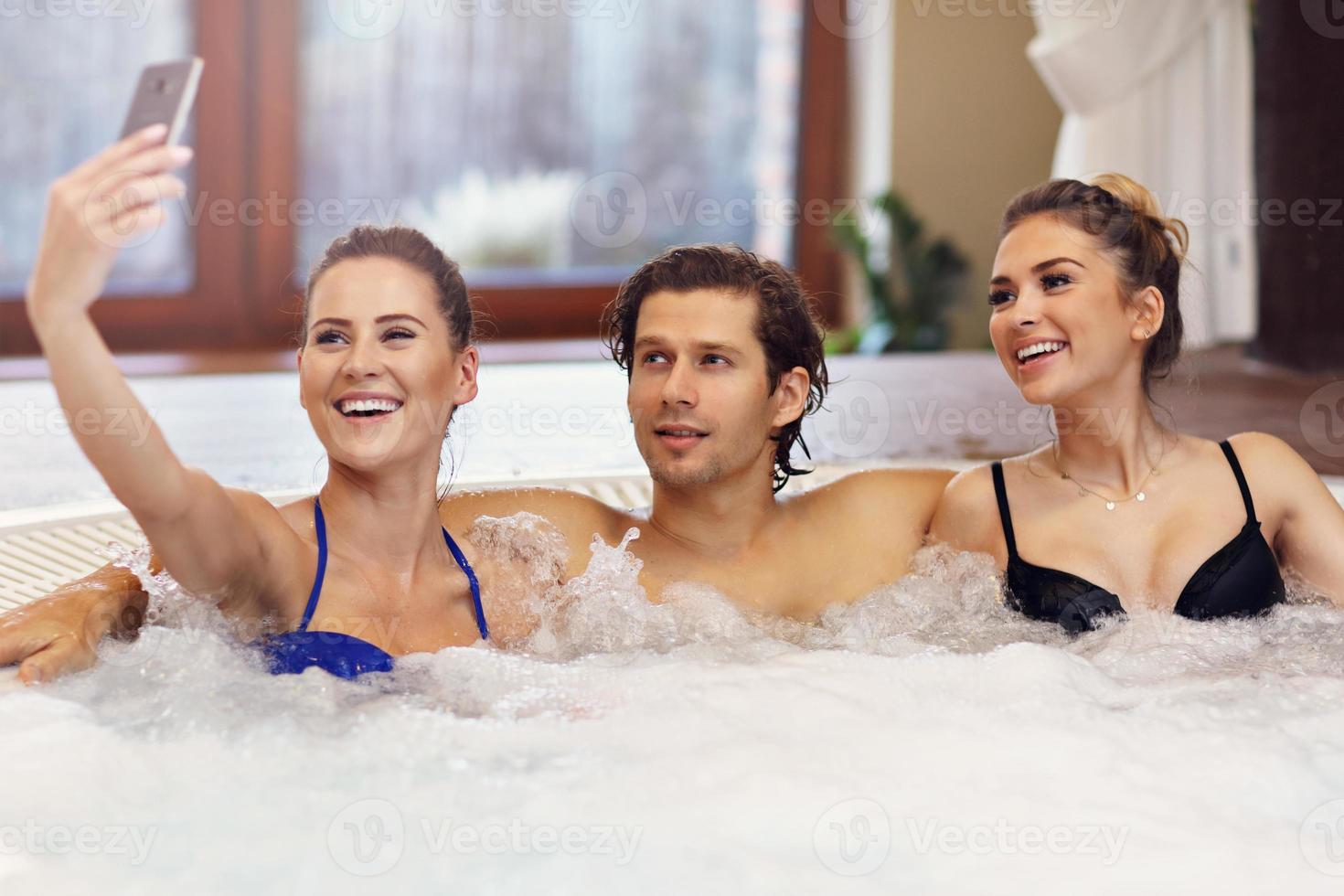 groep van vrienden genieten van jacuzzi in hotel spa foto