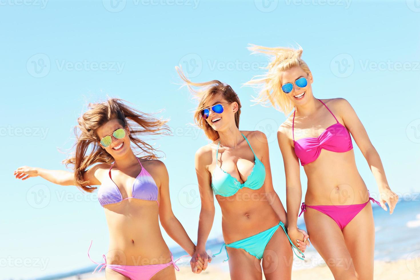 groep van Dames wandelen langs de strand foto