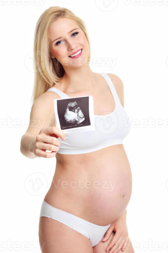 close up van zwangere vrouw met echografie op haar buik foto