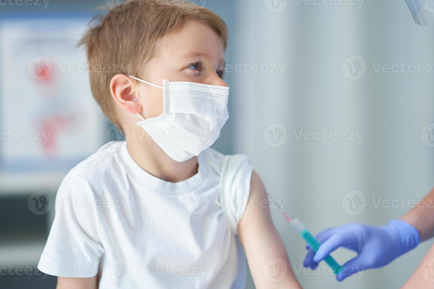 portret van aanbiddelijk weinig jongen wezen vaccineren Bij dokter kantoor foto