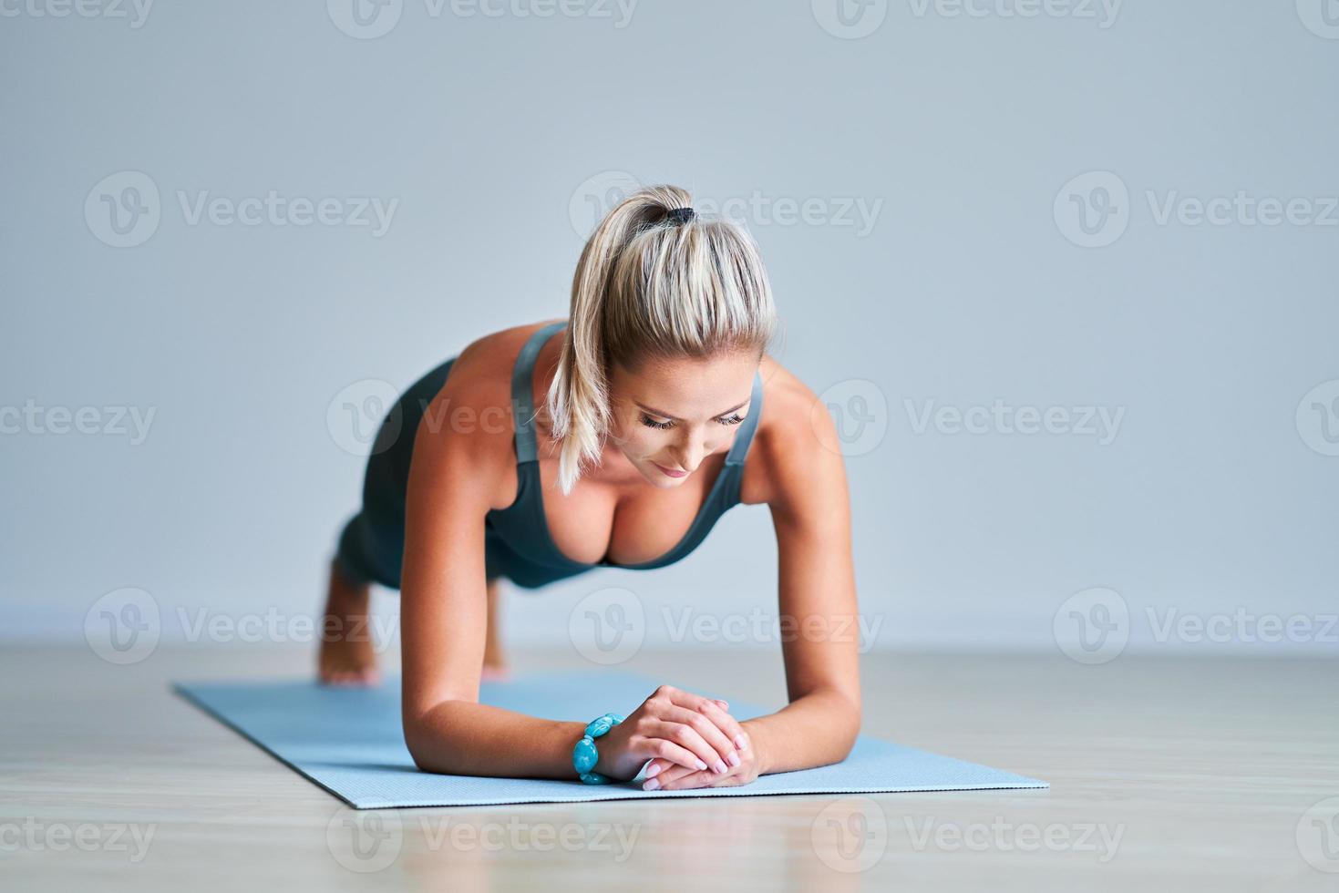 volwassen vrouw beoefenen yoga Bij huis foto