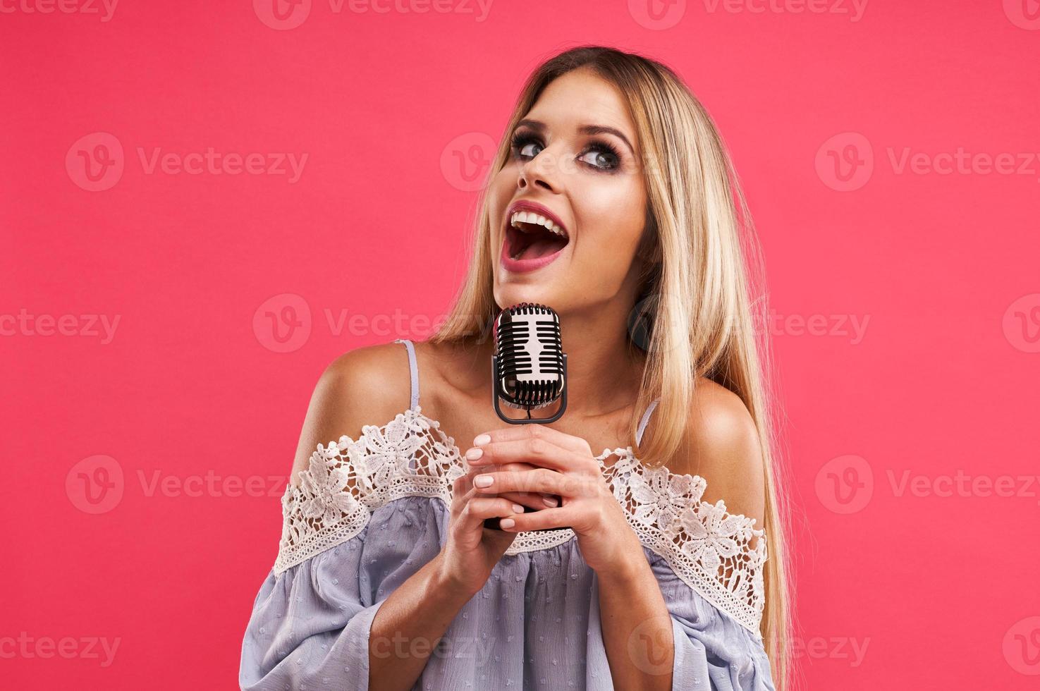 mooi volwassen vrouw poseren over- roze achtergrond foto