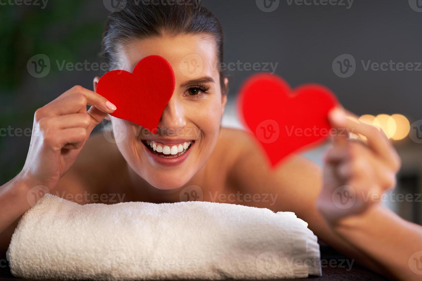 ontspannen vrouw aan het wachten voor een terug massage en Holding hart foto